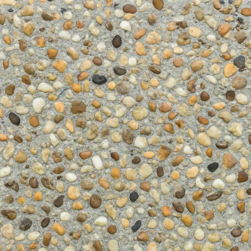 تصویر نمای نزدیک سطح واش بتن با سنگدانههای رنگی و بافت زبر